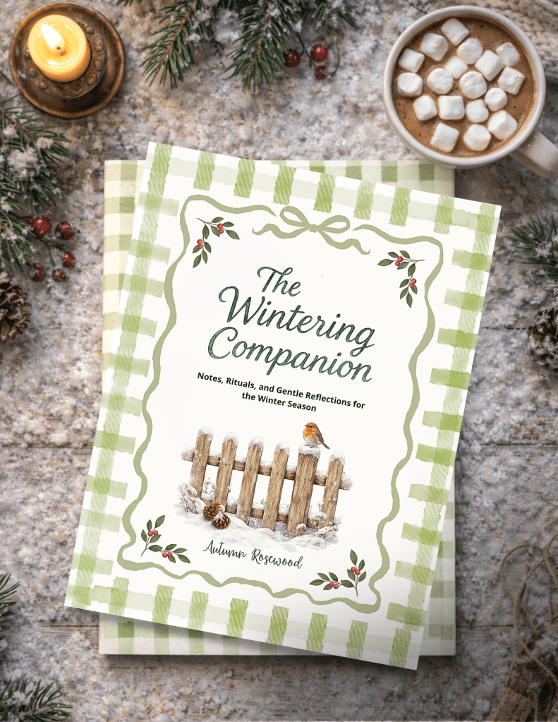 The winter companion book laying on snow and a mug with hot cocoa nearby